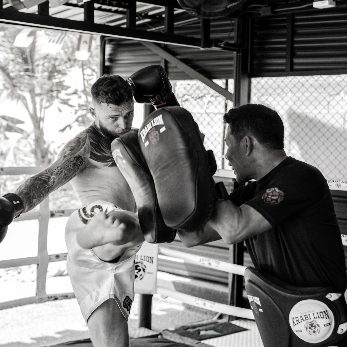 A fighter works pads with Thewaritnoi in the gym's ring.